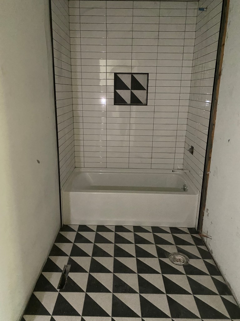Photo of renovated bathroom with black and white custom tile