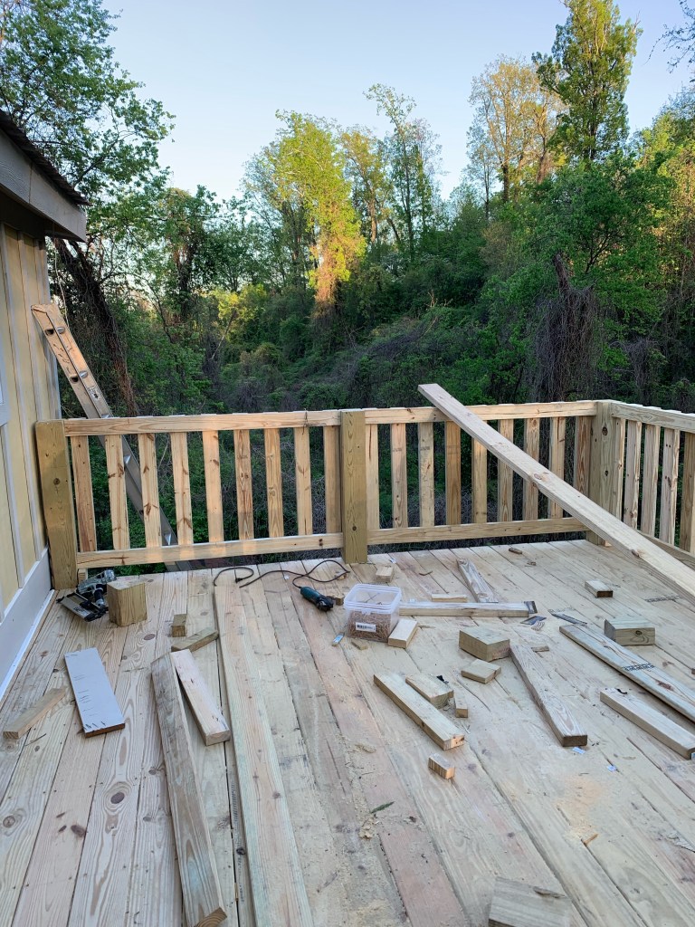 Photo of a back porch being built. Porch is behind house and backs up to wooded area.
