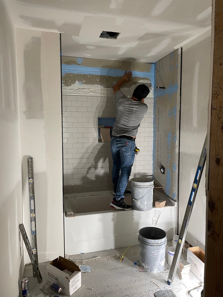 Man installing custom tile in bathroom renovation project